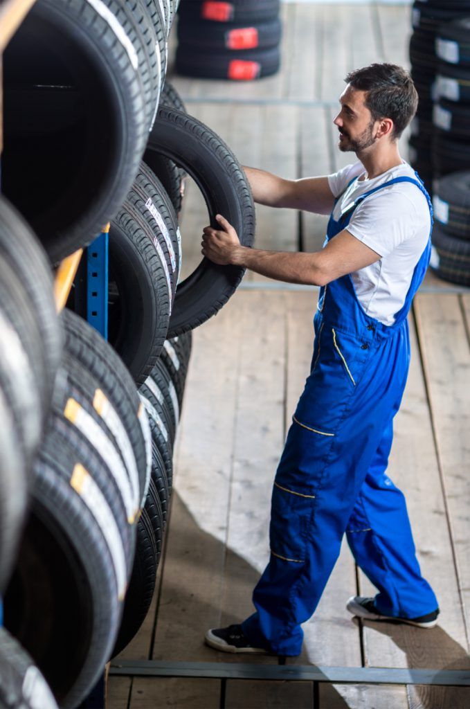 Mechanic picking out a tyre from stock - Lancaster Tyres